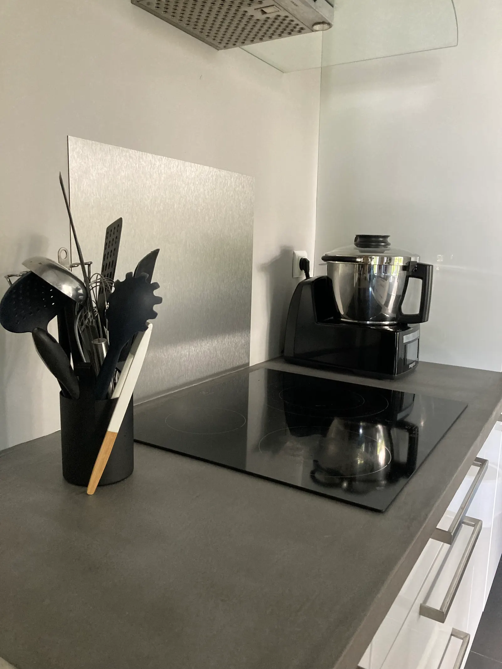 Plan de travail de cuisine en béton ciré gris foncé avec plaque de cuisson encastrée